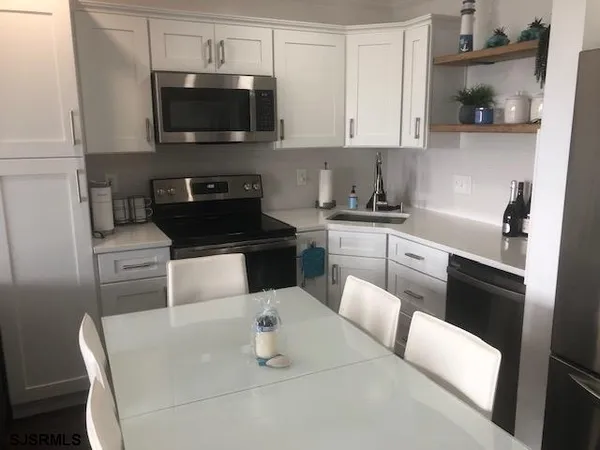 a kitchen with stainless steel appliances a stove a sink a microwave and cabinets