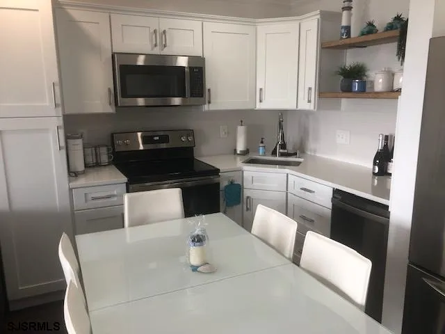 a kitchen with stainless steel appliances a stove a sink a microwave and cabinets