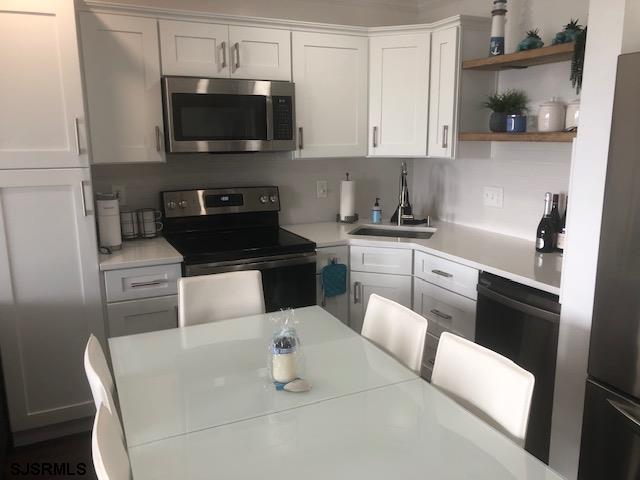 203 East Brigantine Avenue, Unit 206 Brigantine, NJ 08203 - Photo 8 of 14 a kitchen with stainless steel appliances a stove a sink a microwave and cabinets