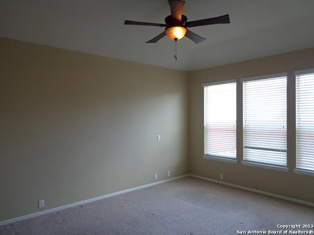 an empty room with a window and a fan