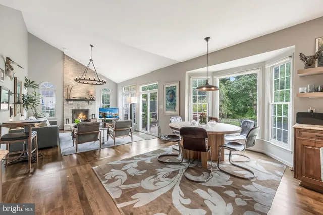 a living room with furniture large window and wooden floor