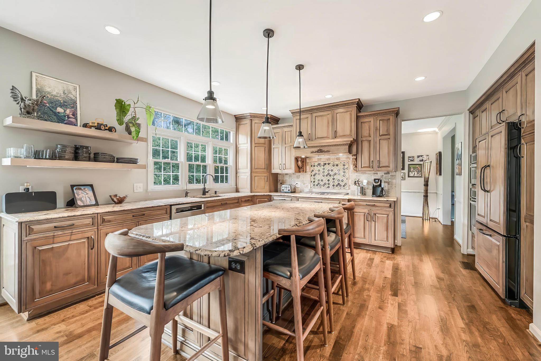 1179 Reston Avenue Herndon, VA 20194 - Photo 15 of 47 a kitchen with stainless steel appliances granite countertop a stove top oven a refrigerator a sink and dining table with wooden floor