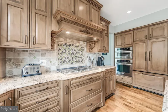 a kitchen with stainless steel appliances granite countertop a refrigerator and a stove