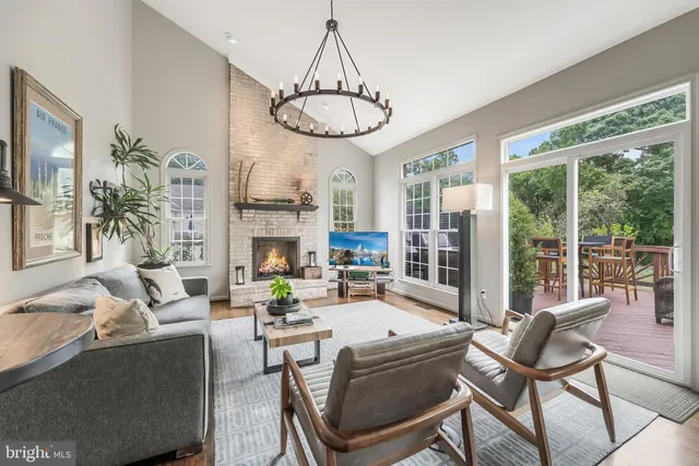 a living room with fireplace furniture and a large window