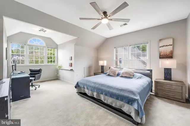 a bedroom with a bed a large window with table and chairs