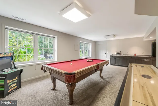 a room with pool table and windows