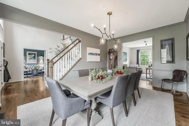 a view of a dining room and livingroom with furniture wooden floor a chandelier