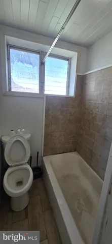 a bath room with a toilet and a tub
