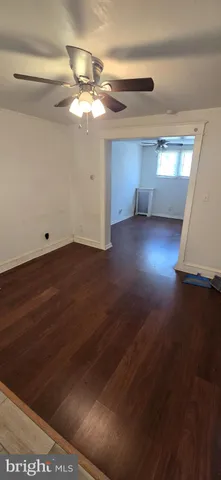 a view of a livingroom with wooden floor and a ceiling fan