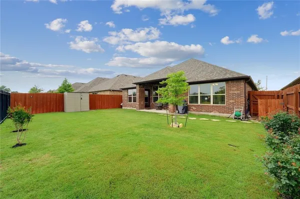 a view of a house with backyard and a tree