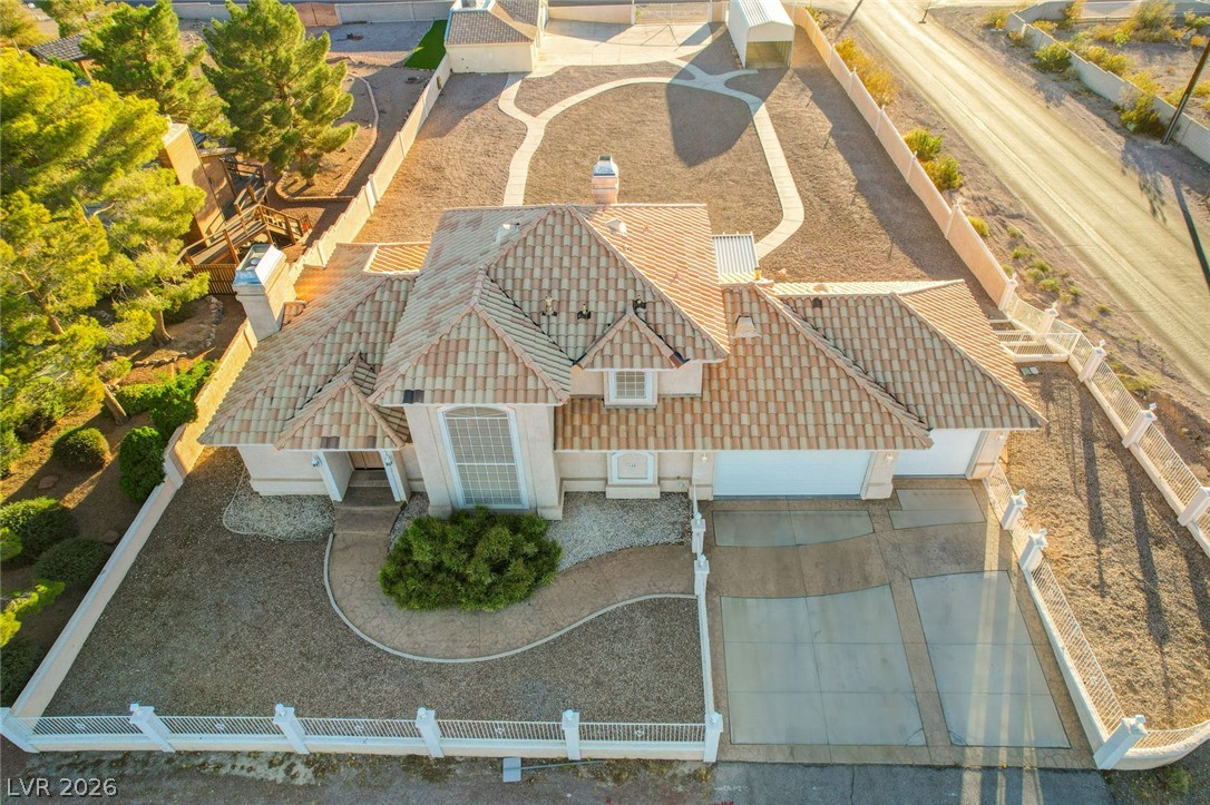 640 North Racetrack Road Henderson, NV 89015 - Photo 5 of 65 An aerial perspective reveals a Mediterranean-style home with a tiled roof, extensive gravel landscaping, and a broad driveway.