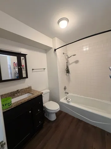 a bathroom with a granite countertop sink a toilet a vanity and mirror