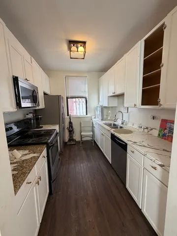 a kitchen with stainless steel appliances a stove sink microwave and cabinets