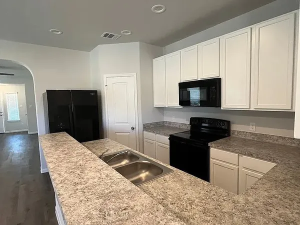 a kitchen with a refrigerator stove and microwave