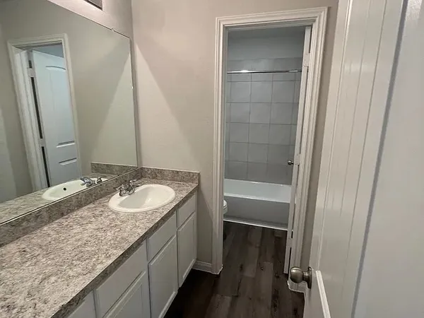 a bathroom with a granite countertop sink and a mirror