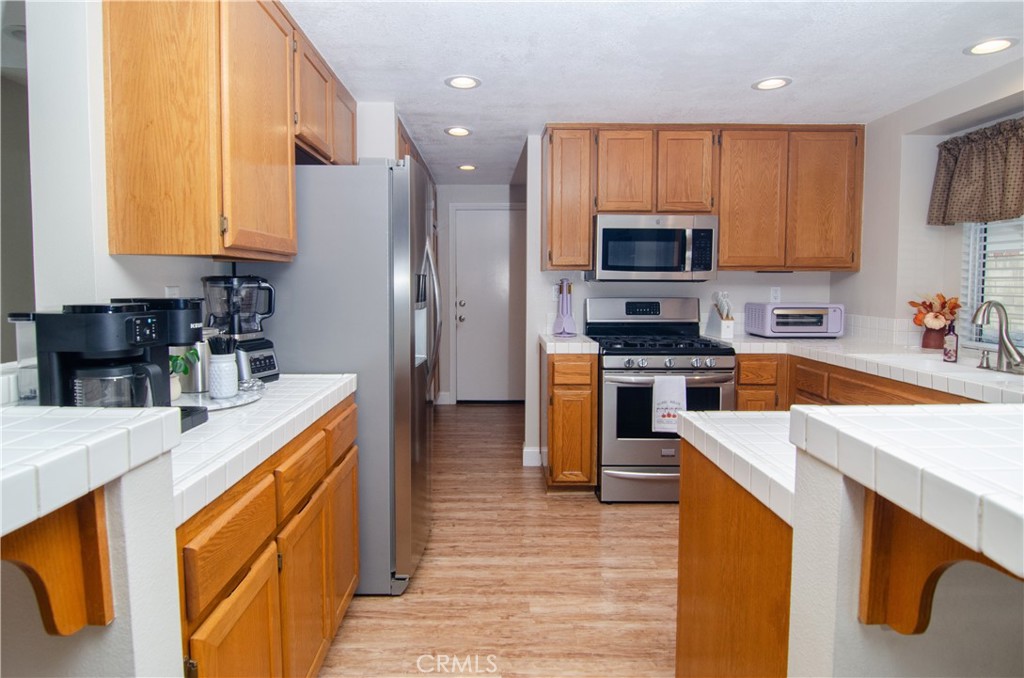 27625 Moonlight Place Castaic, CA 91384 - Photo 18 of 72 a kitchen with stainless steel appliances granite countertop a stove top oven a sink a refrigerator and cabinets