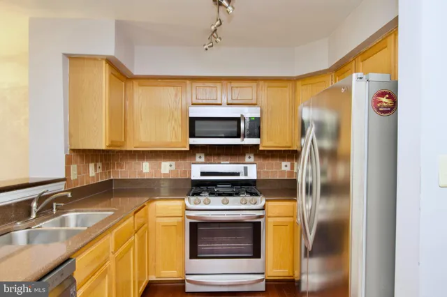a kitchen with stainless steel appliances granite countertop a refrigerator and a sink