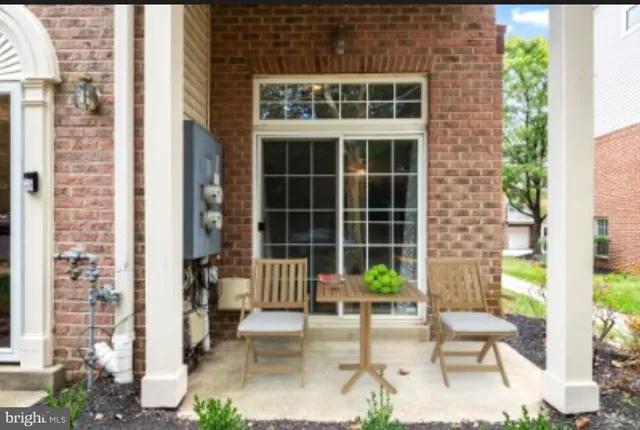 a porch with a bench and chairs