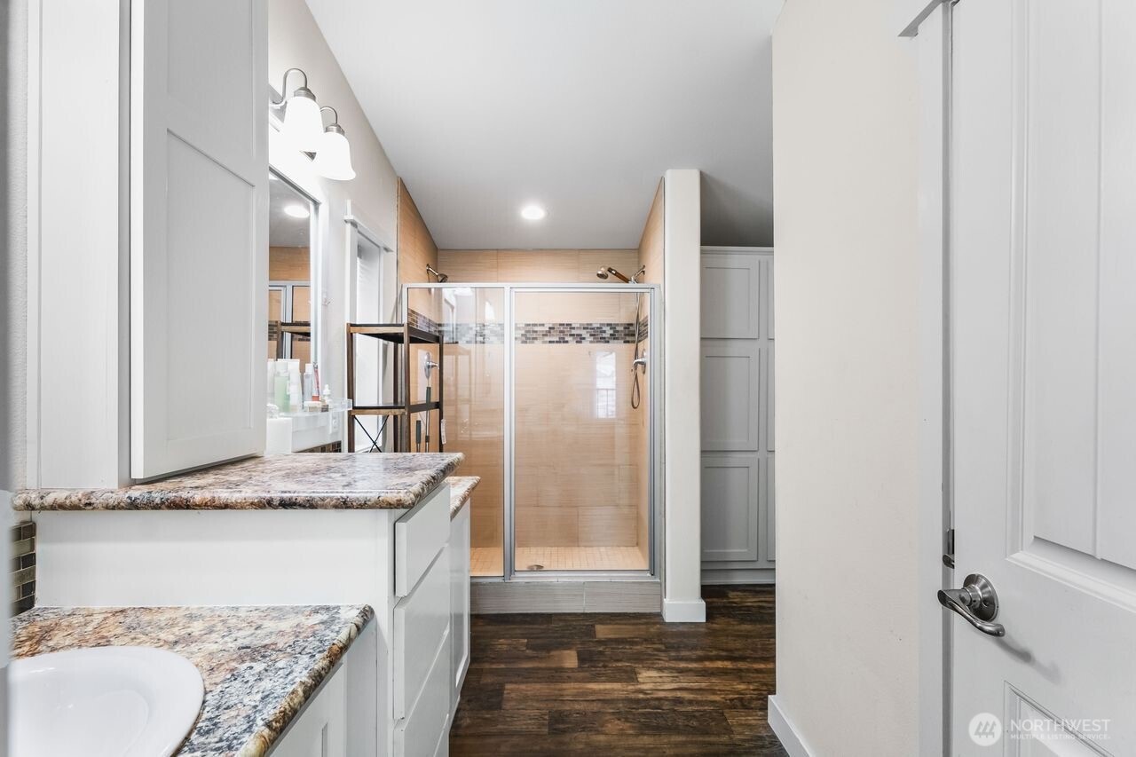 120 L Street Southeast Auburn, WA 98002 - Photo 12 of 20 a bathroom with a granite countertop sink a mirror and shower