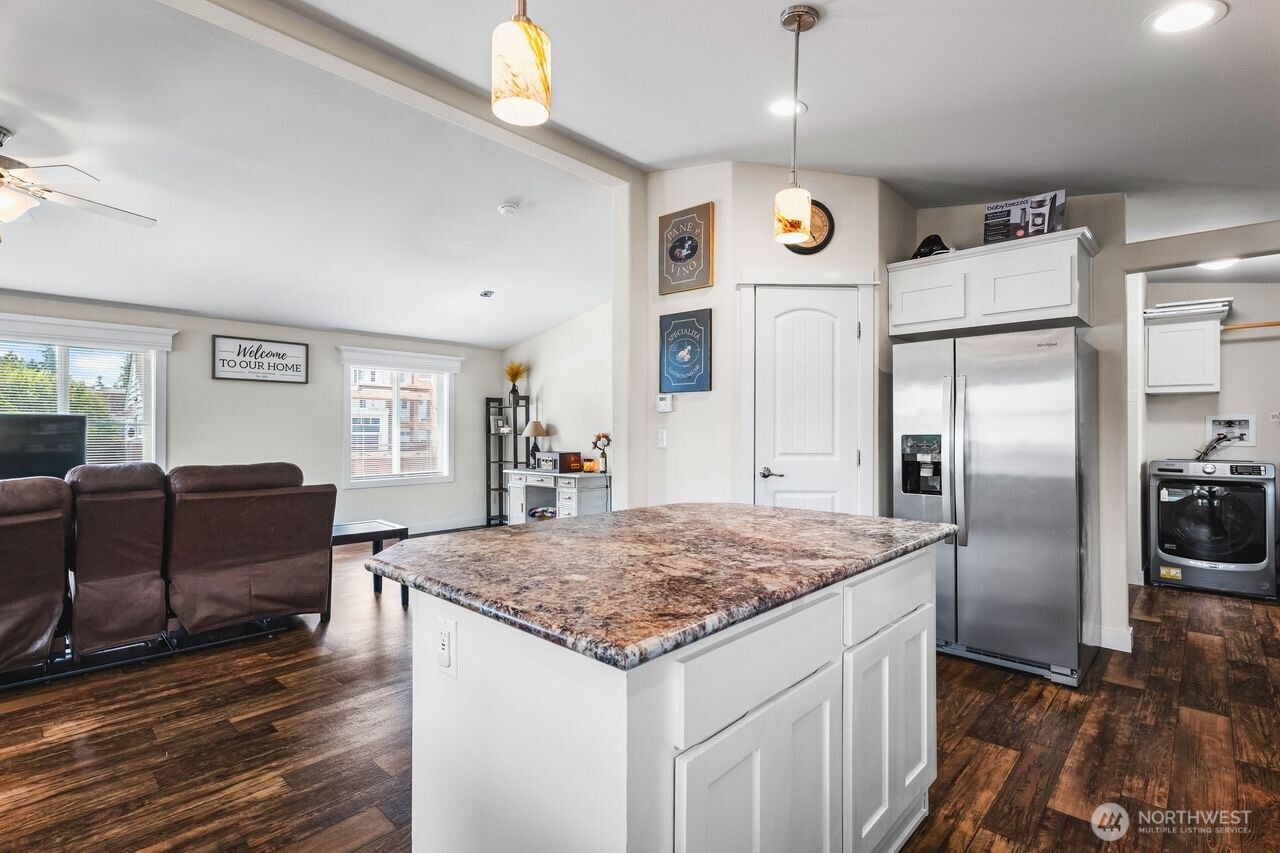 120 L Street Southeast Auburn, WA 98002 - Photo 8 of 20 a kitchen with stainless steel appliances granite countertop a refrigerator oven a sink dishwasher and a dining table with wooden floor