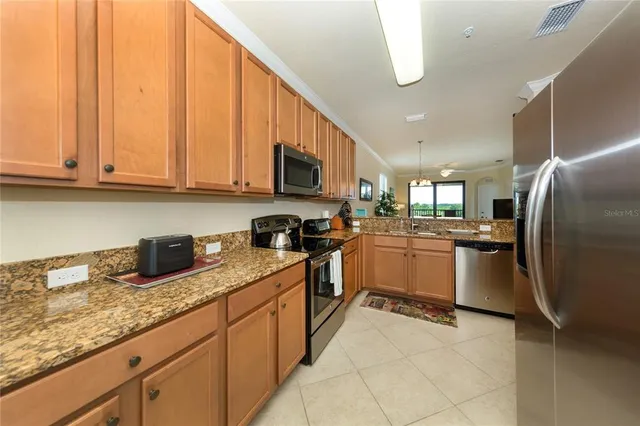 a kitchen with stainless steel appliances granite countertop a refrigerator sink and cabinets