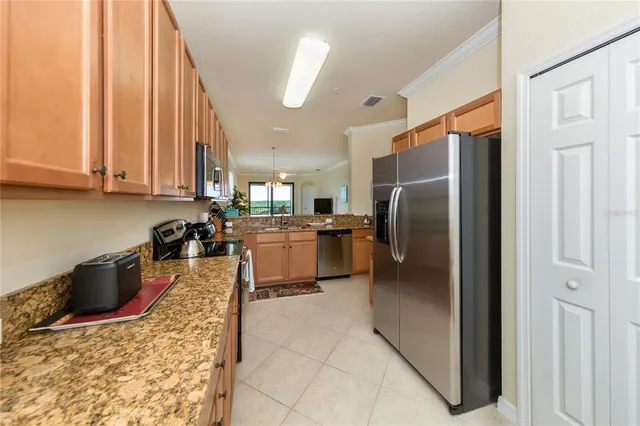 a kitchen with stainless steel appliances granite countertop a refrigerator a stove and a sink
