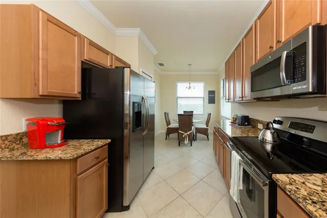 a kitchen with stainless steel appliances granite countertop a stove a sink and a microwave