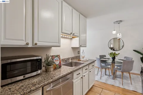 a kitchen with stainless steel appliances granite countertop a sink a stove and a table