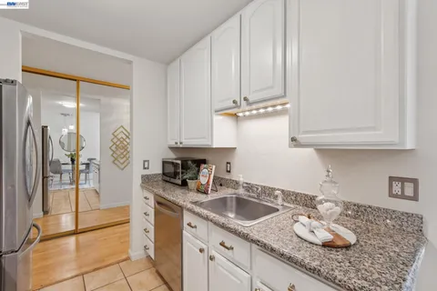 a kitchen with granite countertop stainless steel appliances a refrigerator a stove a microwave and cabinets