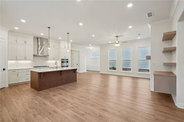 a large kitchen with stainless steel appliances kitchen island a large counter top and a stove top oven