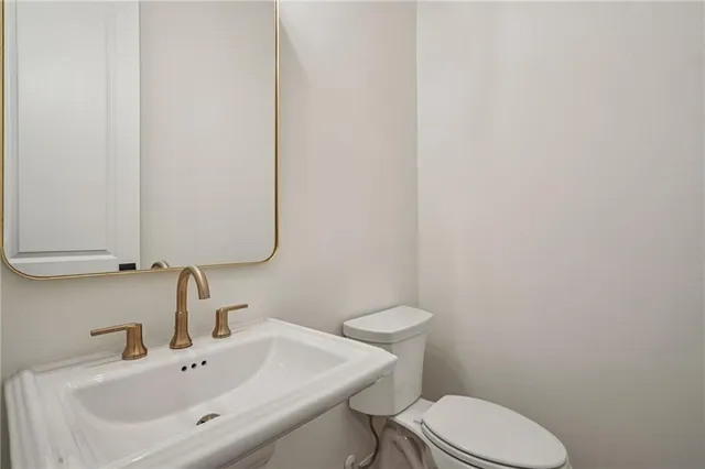 a bathroom with a sink a toilet and mirror