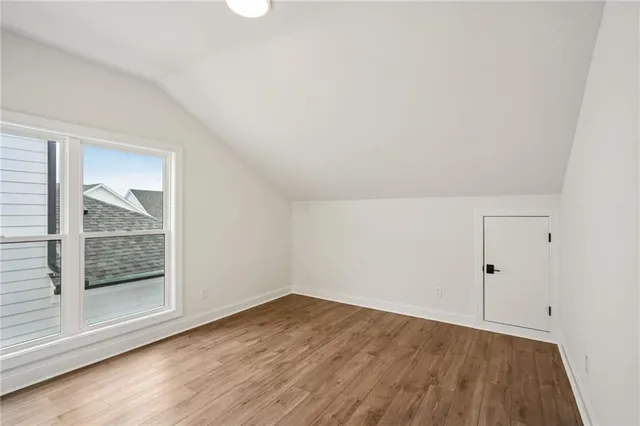 an empty room with wooden floor and window