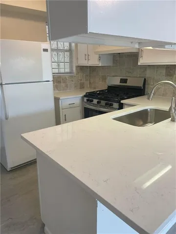 a kitchen with a sink a stove and refrigerator