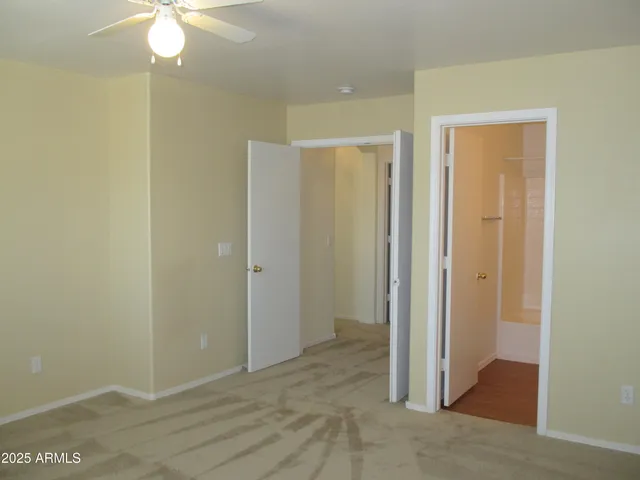 a view of a room with a chandelier fan and closet