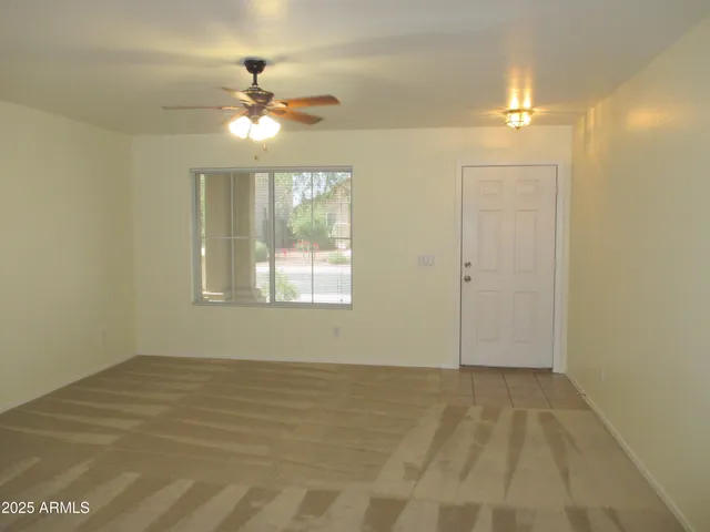 a view of a room with a ceiling fan and hardwood floor