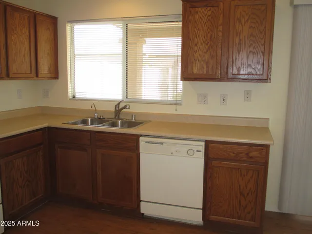 a kitchen with a sink cabinets appliances and a window