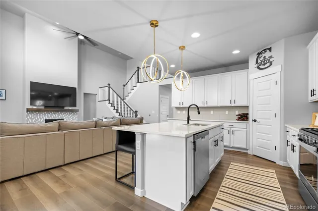 a kitchen with white cabinets and sink