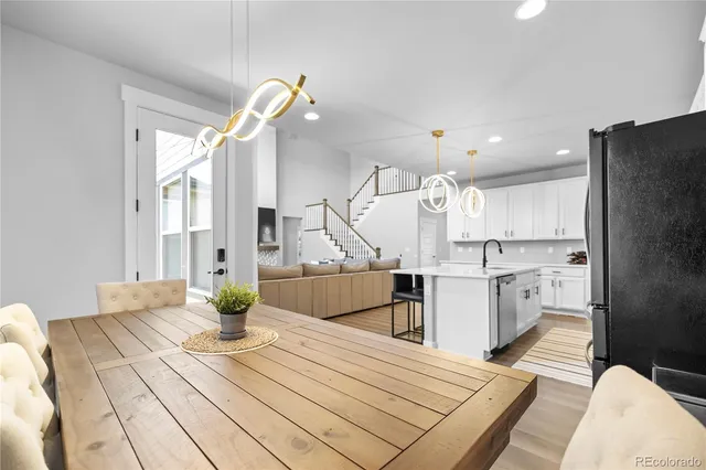 a kitchen view with stainless steel appliances a dining table chairs and a refrigerator