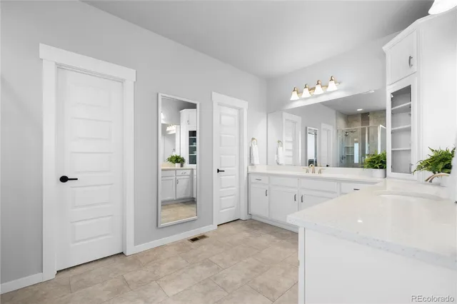 a large en suite bathroom with a granite countertop sink mirror and shower