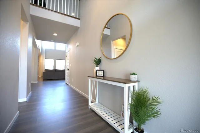 a view of a hallway with wooden floor and glass windows