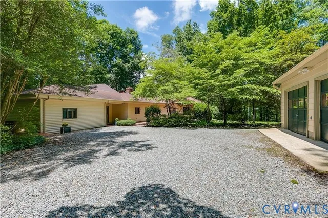a view of a house with a yard and large tree