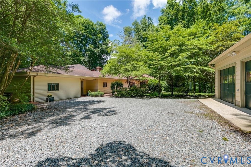 a view of a house with a yard and large tree