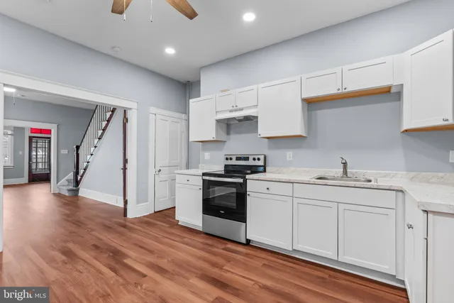 a kitchen with a sink a stove and cabinets