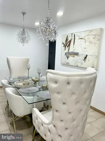 a dining room with furniture a chandelier and window