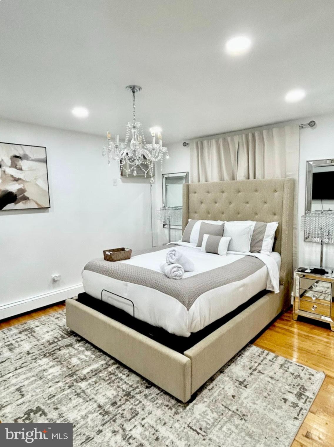 182 Mehrhof Road, Unit 2 Little Ferry, NJ 07643 - Photo 7 of 12 a bedroom with a bed and a chandelier