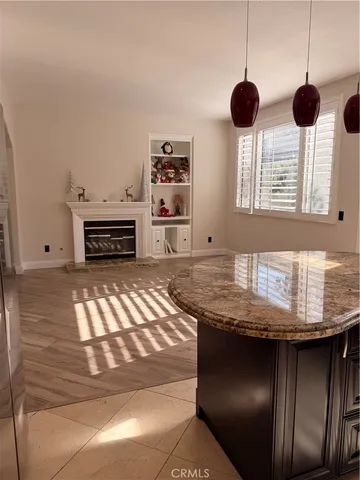 a kitchen with kitchen island granite countertop a sink and a refrigerator
