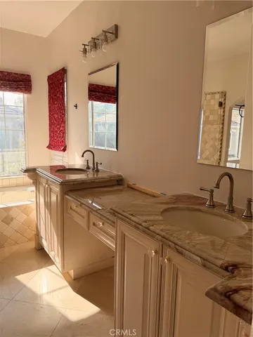 a bathroom with a granite countertop sink and a window
