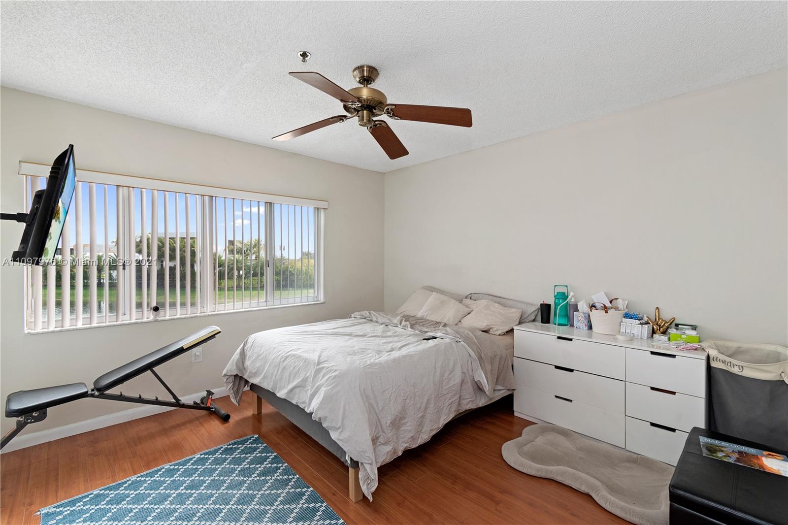 184 Riviera Circle, Unit 325 Weston, FL 33326 - Photo 12 of 27 a bedroom with a bed and wooden floor