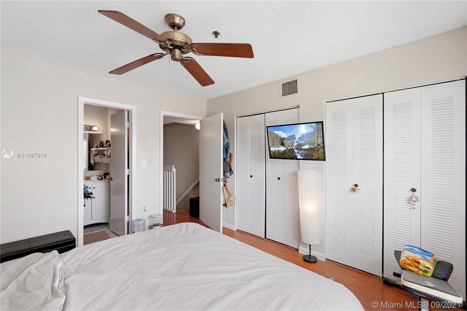 184 Riviera Circle, Unit 325 Weston, FL 33326 - Photo 13 of 27 a bedroom with a bed and a chandelier