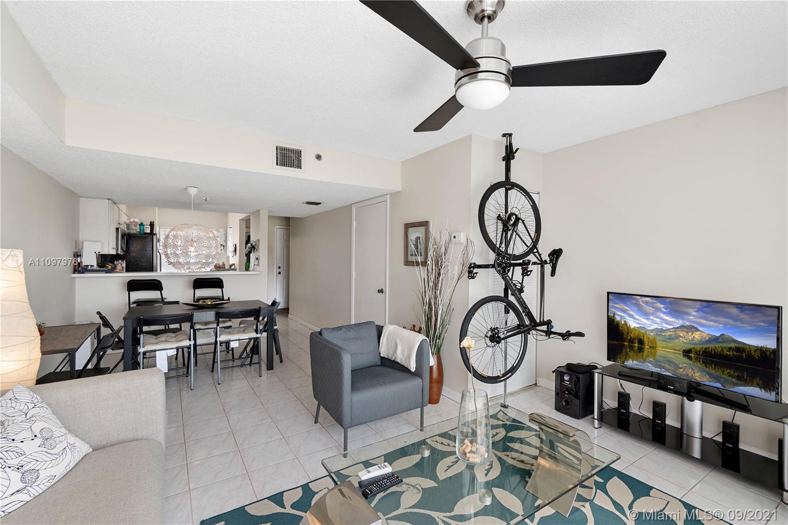 184 Riviera Circle, Unit 325 Weston, FL 33326 - Photo 3 of 27 a living room with furniture a flat screen tv and a window